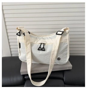 Dettaglio della borsa a tracolla in nylon crema con tessuto a pieghe impermeabile e zip nere