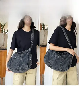 Close-up of black denim tote bag with washed texture and silver buckle detailing