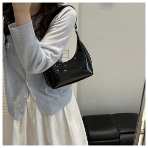Dettaglio della borsa hobo in vernice nera lucida che mostra l'elegante forma a mezzaluna