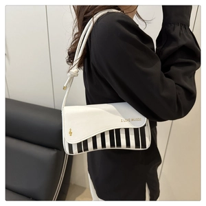 Détail du motif de touches de piano et de l'imprimé I LIKE MUSIC sur le sac blanc