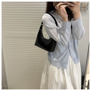 Détail d'un sac hobo en cuir verni noir avec finition brillante et fermeture éclair