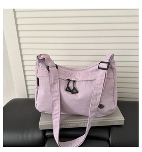 Dettaglio della borsa in nylon lavanda con tasca frontale e tracolla regolabile
