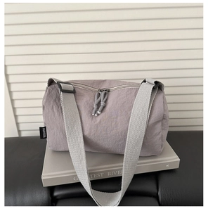 Detailed macro view of lilac cylinder shoulder bag fabric texture and black woven label
