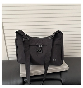 Dettaglio di una borsa a tracolla in nylon nero impermeabile con scomparti con cerniera