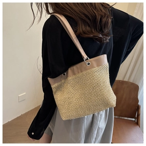 Detail of straw woven mesh and tan faux leather texture on minimalist summer tote bag