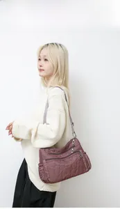 Detail of mauve nylon shoulder bag with heart quilted pattern and multiple zipper pockets