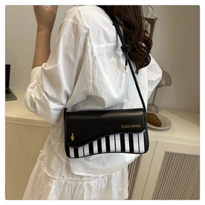 Détail du sac en cuir PU piano avec notes de musique et texte doré I LIKE MUSIC