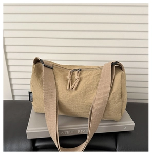 Detail of khaki nylon crossbody bag featuring double zippers and wide woven strap
