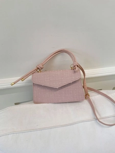 Vue détaillée de la texture jacquard rose et des garnitures dorées du petit sac carré