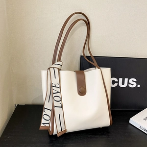 Minimalist cream and brown tote bag with 'LOVE' ribbon detail and gold metal feet