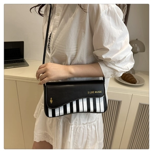 Détail du sac selle à thème musical avec touches de piano et broderie