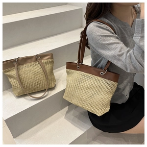 Detail showing high-quality straw weave texture and brown leather strap on summer tote bag