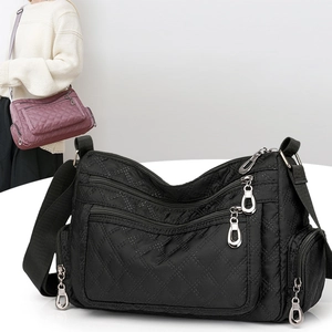 Black quilted nylon crossbody bag with multi-zipper compartments and adjustable strap