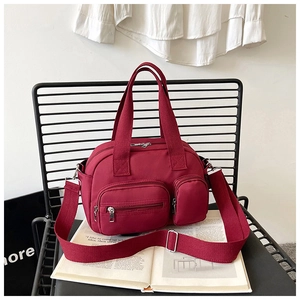 Détail du sac cabas en nylon bordeaux avec multi-poches et bandoulière large en tissu