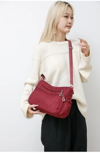 Detail of burgundy large capacity shoulder bag featuring heart-shaped quilted pattern