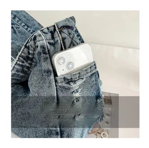 Detail view of denim bag side pocket holding a smartphone for practical storage