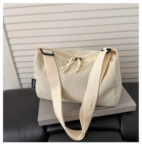 Detail of beige nylon crossbody bag with wide strap and metallic zipper closure