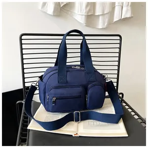 Détail d'un sac bandoulière bleu marine en nylon imperméable avec plusieurs poches
