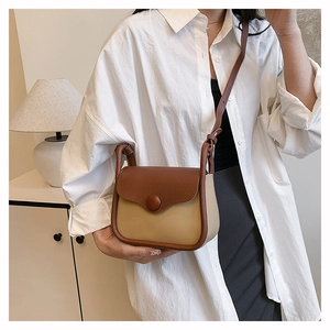 Detail of vintage two-tone shoulder bag featuring a brown flap and warm beige body