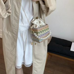 Ethnic straw bucket bag with colorful geometric patterns, pearl handle and chain strap
