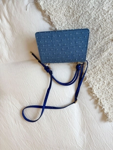 Détail du sac à main en denim bleu avec broderie étoilée et boucles dorées