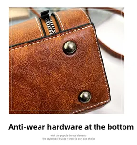 Detailed macro view of the protective metal studs on the vintage brown leather handbag base