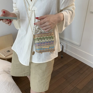 Chic woven crossbody bag with colorful stripes, pearl handle, and gold chain strap