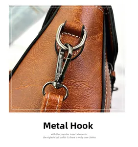 Detail of gunmetal hook hardware on brown leather crossbody bag with white stitching