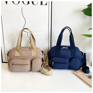 Détail des poches zippées sur des sacs à main multifonctionnels beige et bleu marine