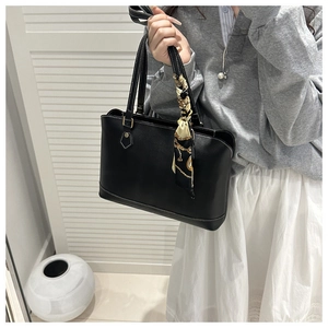 Detail of black tote bag with white contrast stitching and silk scarf wrap on handle