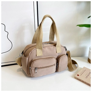 Détail du sac à bandoulière en nylon kaki avec poches avant et fermetures éclair