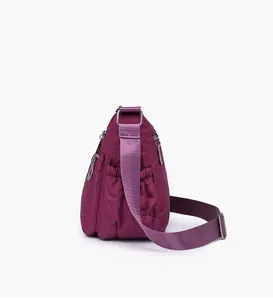 Detail view of purple quilted nylon bag with silver zippers and side pockets