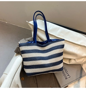 Detail of blue and white striped woven tote bag with premium leather handles for summer