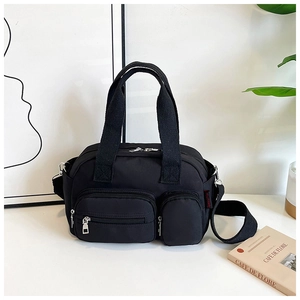 Détails d'un sac à main noir multi-poches en nylon avec fermetures éclair et étiquette de marque