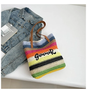 Detailed top view of striped straw tote bag with Summer embroidery and leather straps