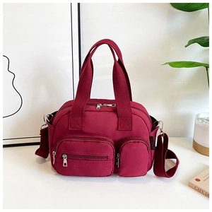 Vue détaillée du sac en nylon bordeaux avec poches zippées et larges poignées de transport