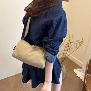 Large beige minimalist canvas crossbody bag for women on a model with denim dress