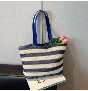 Detail of blue and white striped woven tote bag with premium navy leather handles