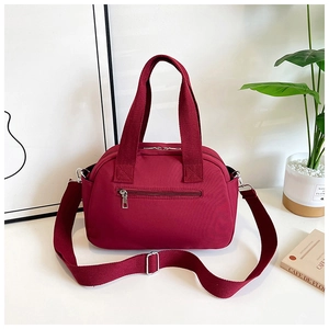 Vue détaillée du sac en tissu bordeaux polyvalent avec fermetures éclair et bandoulière