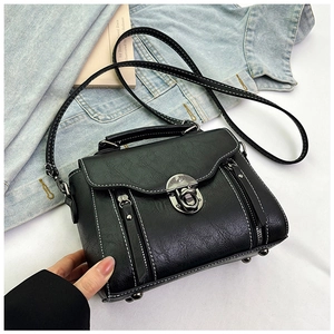 Detailed close-up of a black PU leather crossbody bag with white contrast stitching