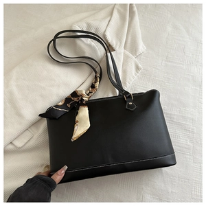 Detail of black tote bag featuring decorative silk scarf and white contrast stitching