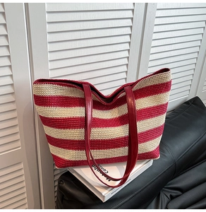 Détail du sac fourre-tout tissé à rayures rouges et blanches avec anses en cuir rouge