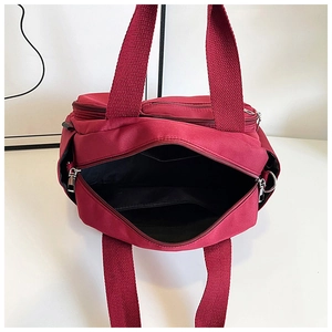 Détail du sac fourre-tout en nylon bordeaux avec compartiment et poche intérieure zippée