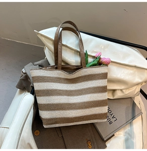 Détail du sac cabas tissé à rayures avec poignées en similicuir marron et une tulipe