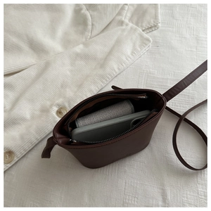 Detail view of compact retro brown bucket bag interior showing daily essentials storage
