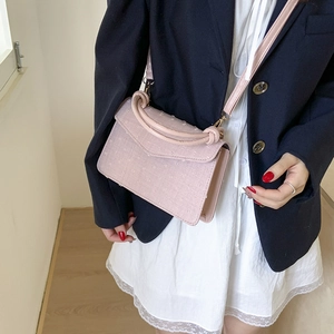 Petit sac carré rose avec poignée tressée porté à l'épaule pour style décontracté