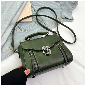 Detailed view of dark green retro handbag featuring metal lock and decorative zippers