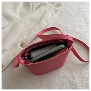 Internal view of pink leather bucket bag showing storage space for a smartphone