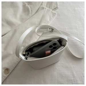 Internal view of a white mini bucket bag showing smartphone capacity and dark lining