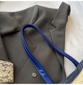 Détail de la bandoulière en cuir bleu marine et texture tissée bicolore de ce cabas